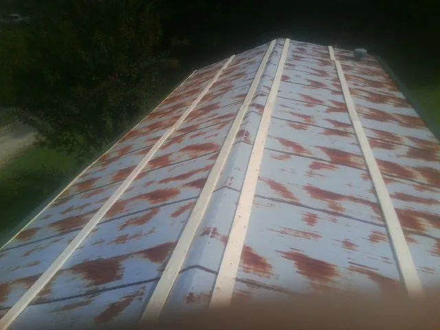 Rusted metal roof panels with new wood purlins before replacement — Storm Damage Roof Repair in Deatsville by Roofing Brothers