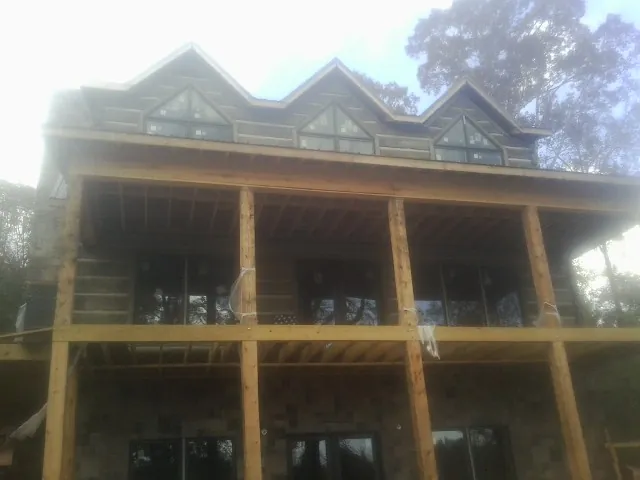 Dormers and porch framing on a large log home under construction — Roof Coating work by our crew in Deatsville