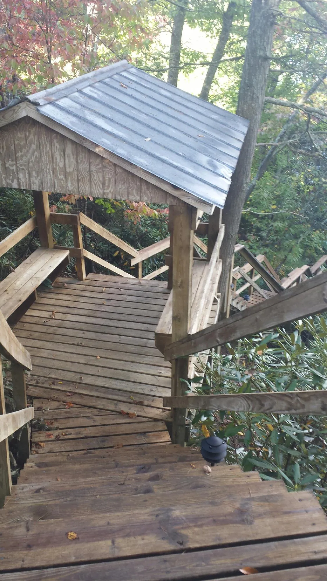 Metal roofed shelter over wooden steps on a wooded walkway — Skylight Repair & Installation work by our crew in Deatsville