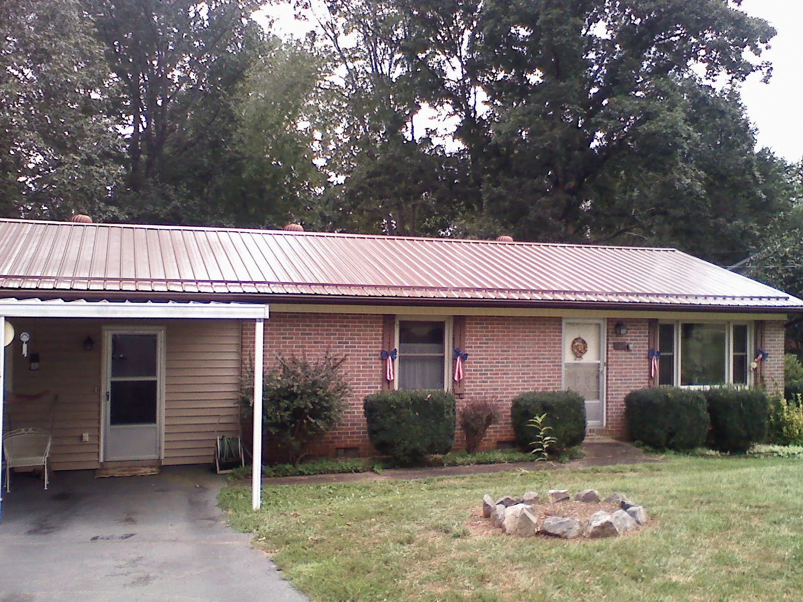 Bronze metal roof and carport on a brick ranch home — Roof Repair work by our crew in Deatsville